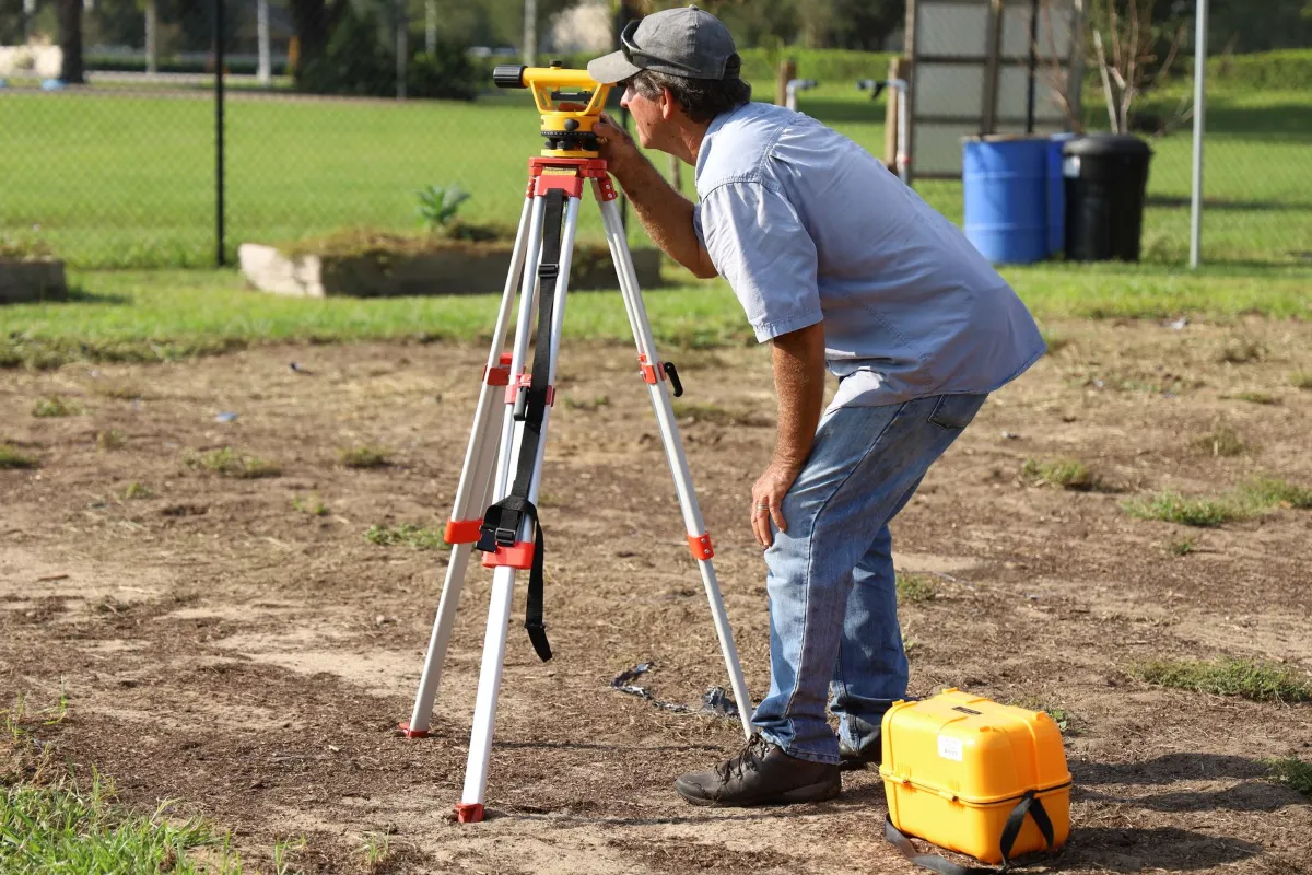 Surveyor with a level on a house lot