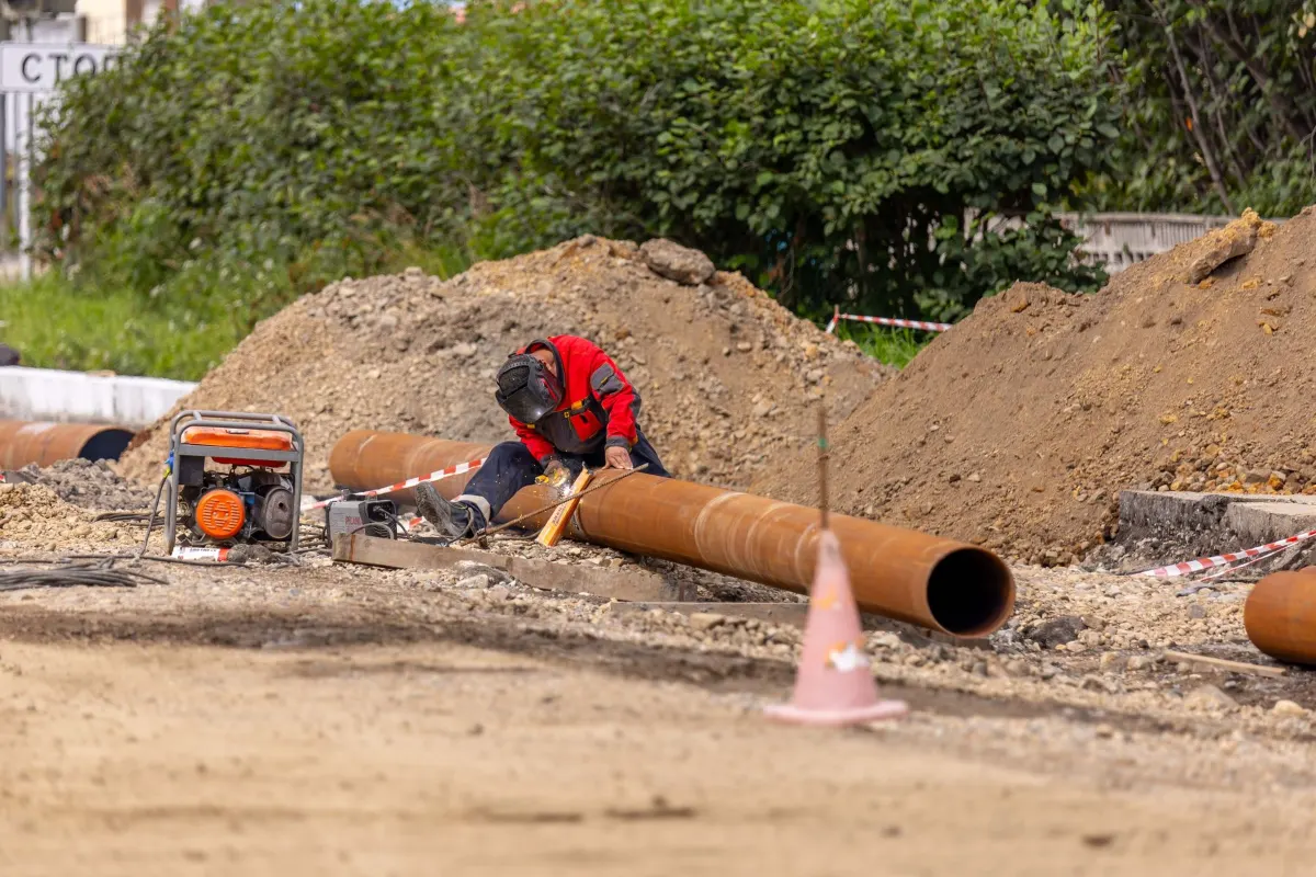 Worker laying pipe in a trench